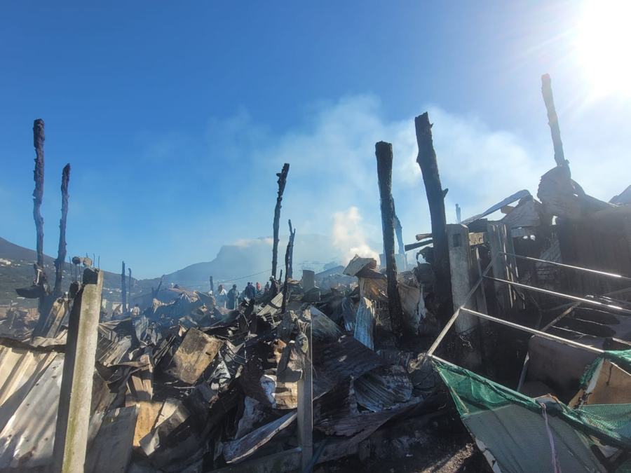Burnt shacks and corrugated iron under a smoky sky